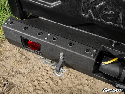 Close-up of a black SuperATV bumper on a vehicle, with grass and dirt in the background.