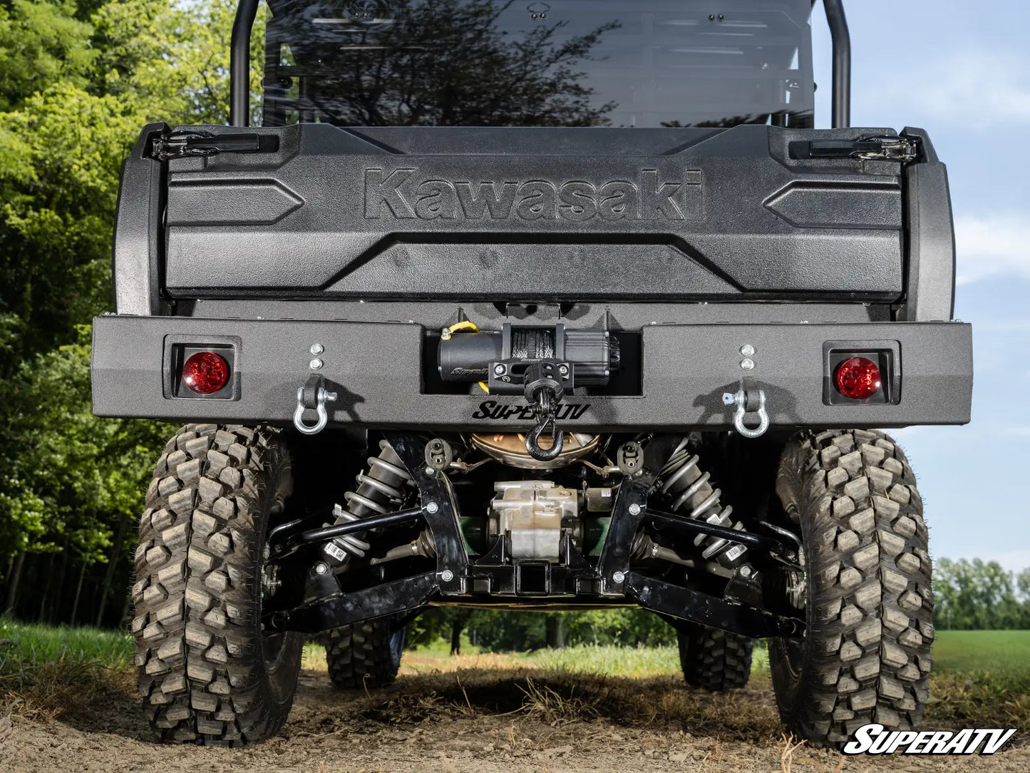 Kawasaki SuperATV vehicle with large tires and visible branding in an outdoor setting.