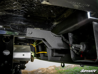 Close-up of a SuperATV product on a vehicle, showing mechanical components.