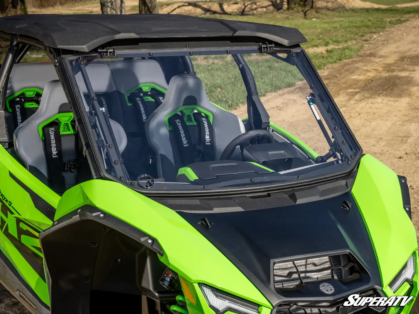 Green and black SuperATV UTV with open roof and visible branding.