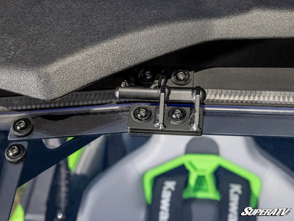 Close-up of a hinge on a SuperATV product with a green and black logo in the background.