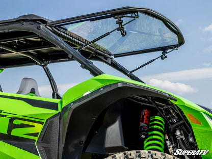 Green off-road vehicle with open canopy against a blue sky