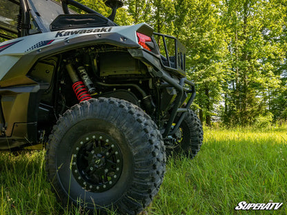 Kawasaki ATV in a grassy field with trees in the background
