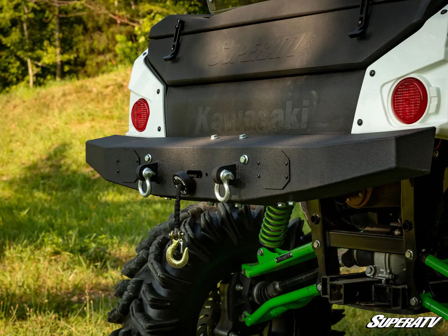 Close-up of a Kawasaki SuperATV vehicle with grass in the background