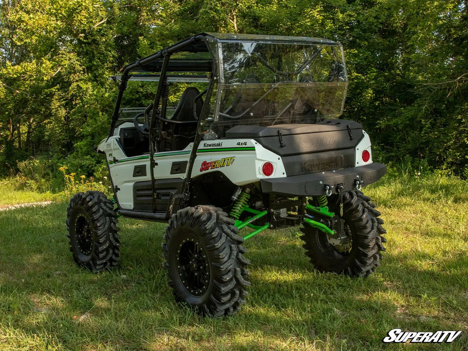 Kawasaki Mule SuperATV in a grassy area with trees in the background