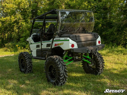 Kawasaki Mule SuperATV in a grassy area with trees in the background