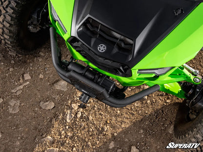 Close-up of a bright green and black off-road vehicle or ATV front bumper area on a rocky dirt ground, with a visible SuperATV logo watermark in the bottom right corner.