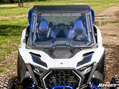 White and blue off-road vehicle with transparent roof on a dirt path