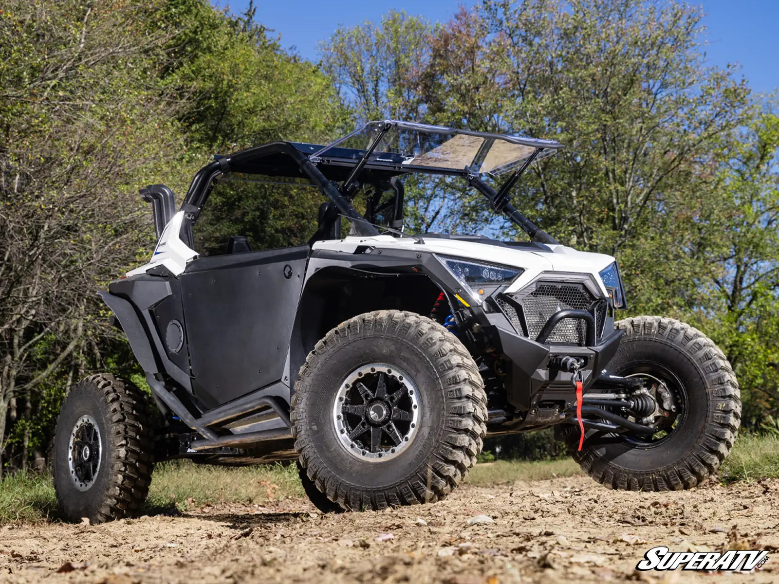 Off-road vehicle on a dirt path with trees in the background