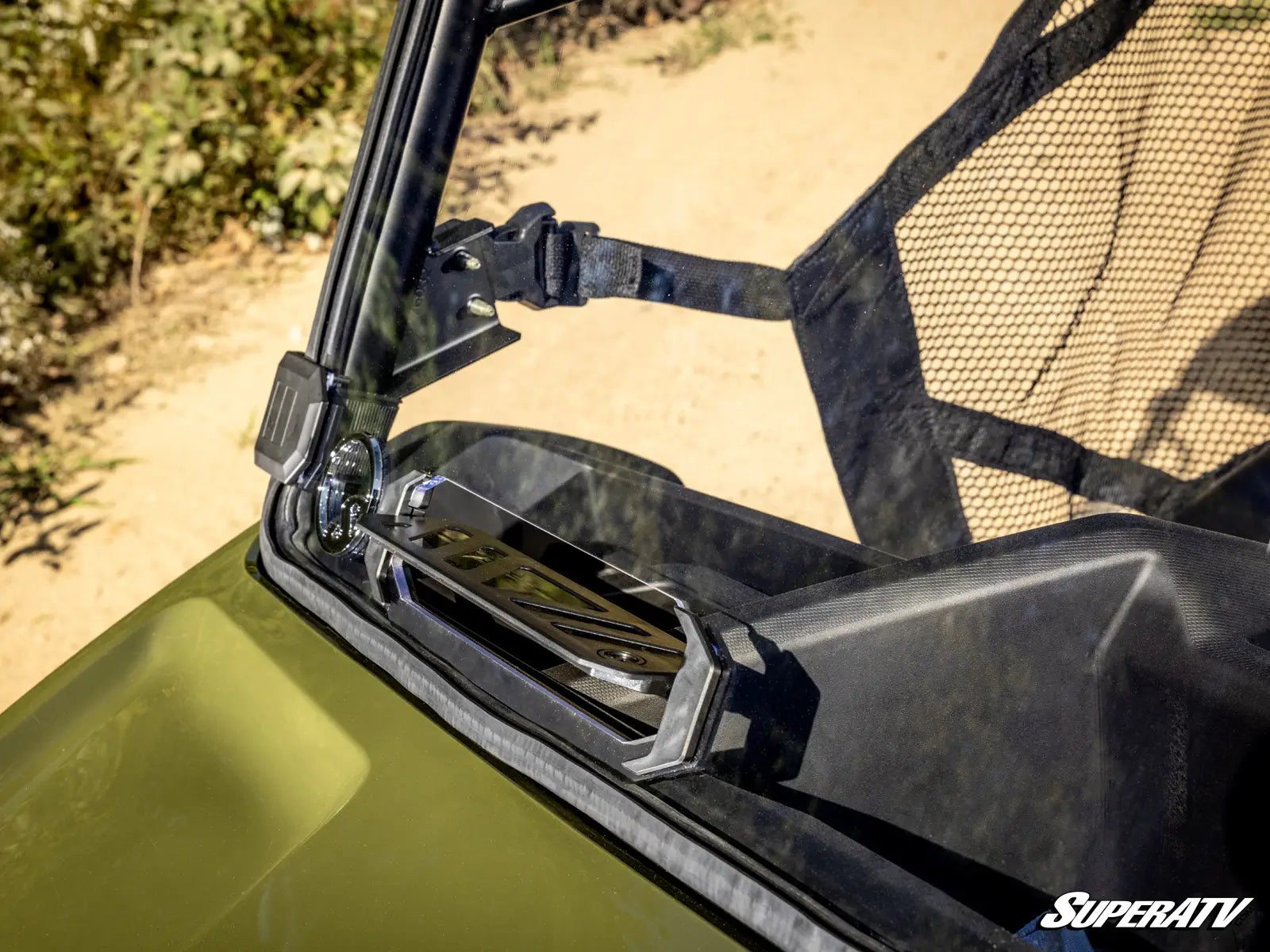Close-up of a green ATV with a black windshield and SuperATV logo.