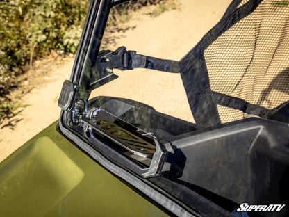 Close-up of a green ATV with a black windshield and SuperATV logo.