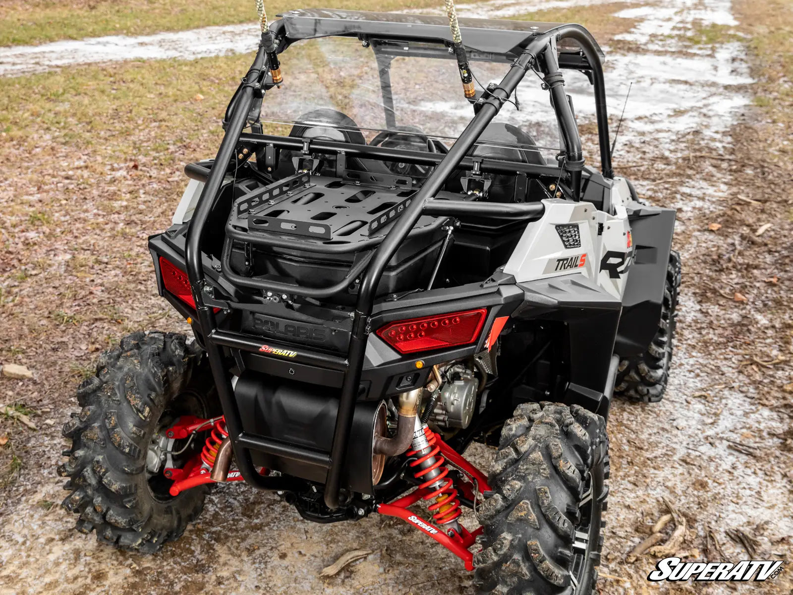 Side view of a Polaris RZR XP 1000 on a muddy terrain with 'SuperATV' branding.