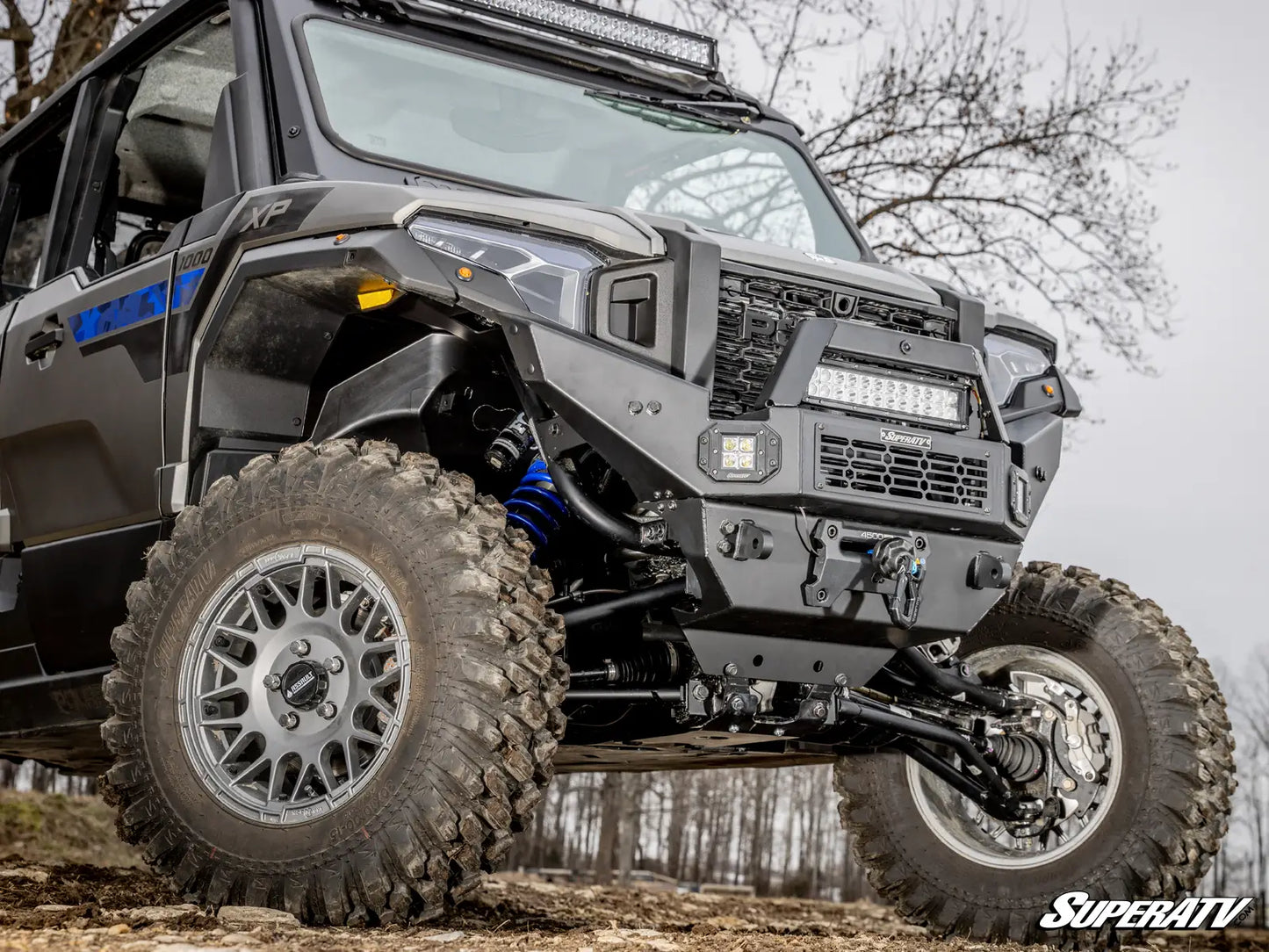 Off-road vehicle with large tires and visible SuperATV branding on a natural background.