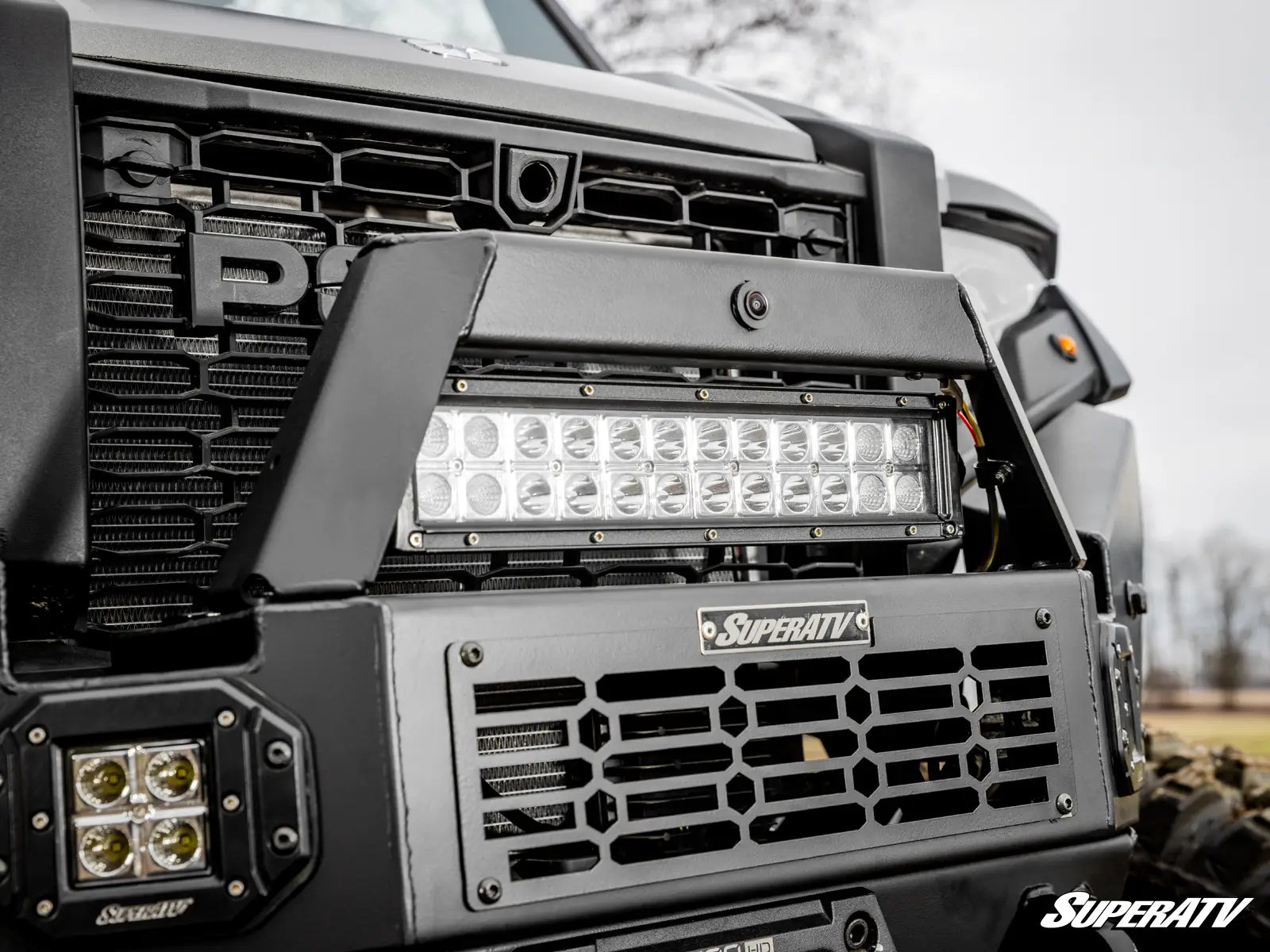 Close-up of a vehicle's front bumper with LED lights and SuperATV branding.