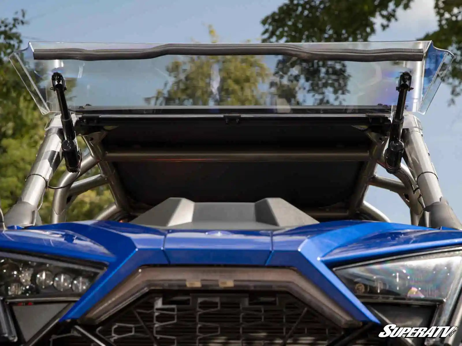 Close-up of a blue off-road vehicle with a clear windshield and SuperATV logo.