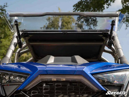 Close-up of a blue off-road vehicle with a clear windshield and SuperATV logo.