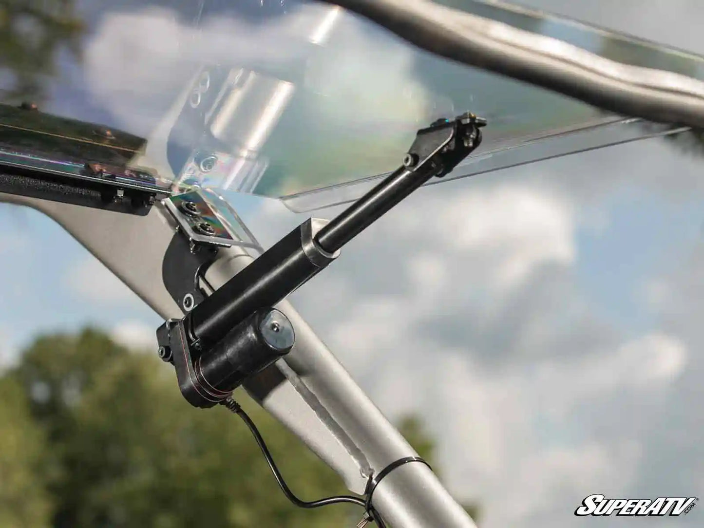 Close-up of a windshield wiper mechanism on a SuperATV product with a blurred outdoor background.
