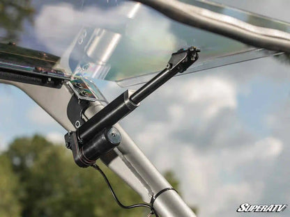 Close-up of a windshield wiper mechanism on a SuperATV product with a blurred outdoor background.