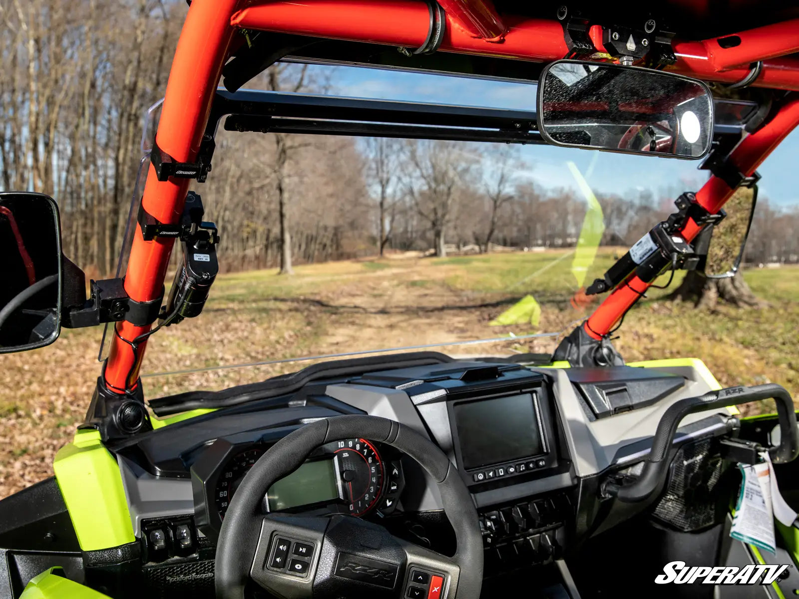 Close-up of a SuperATV vehicle interior with dashboard and steering wheel.