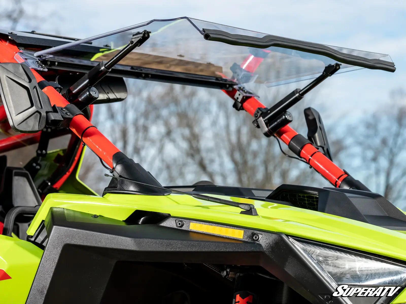 Close-up of a SuperATV windshield on an ATV with a blurred natural background
