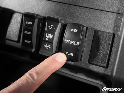 Close-up of a finger pressing a 'Windshield Close' switch on a SuperATV control panel.