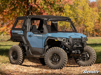 Blue Polaris SuperATV vehicle on a dirt path with autumn trees in the background