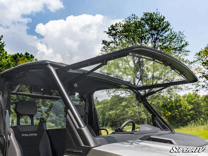 Side view of a Polaris vehicle with an open door in a forest setting