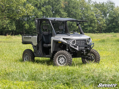 SuperATV Ranger vehicle in a grassy field with trees in the background