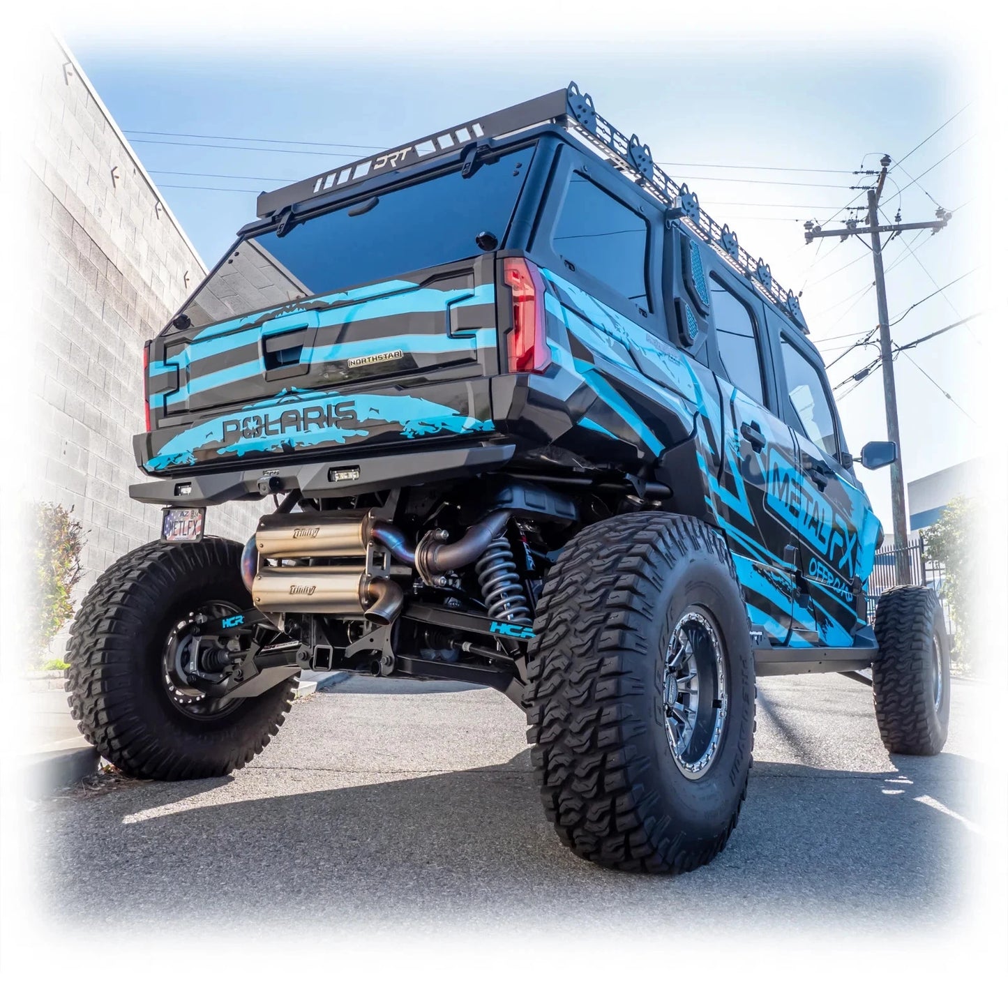 Blue off-road vehicle with 'Polaris' branding on a street.