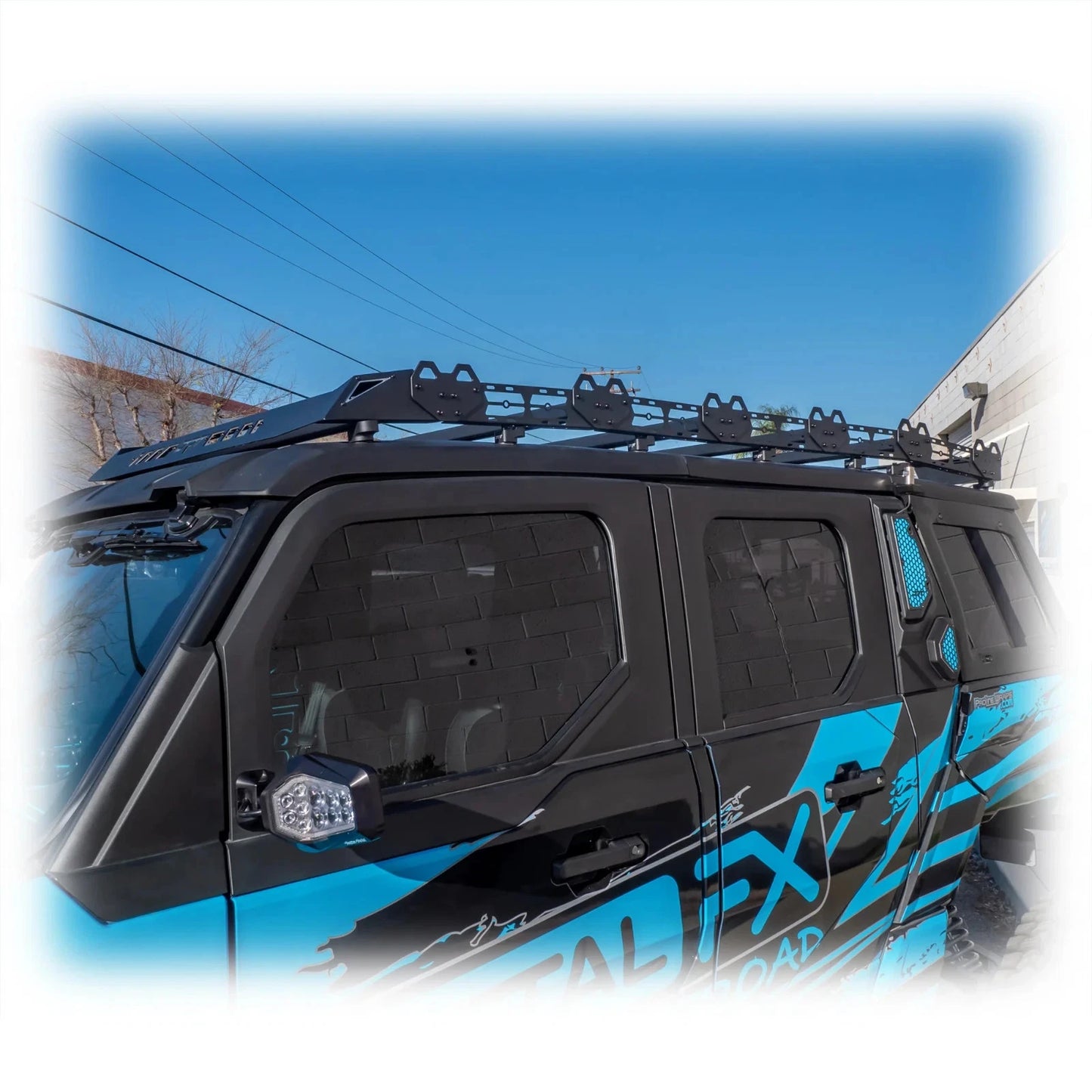 Black roof rack on a blue vehicle with clear sky background