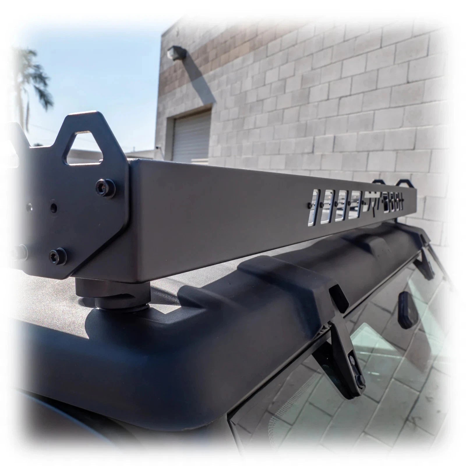 Black vehicle bumper with 'Rugged Ridge' branding against a building background