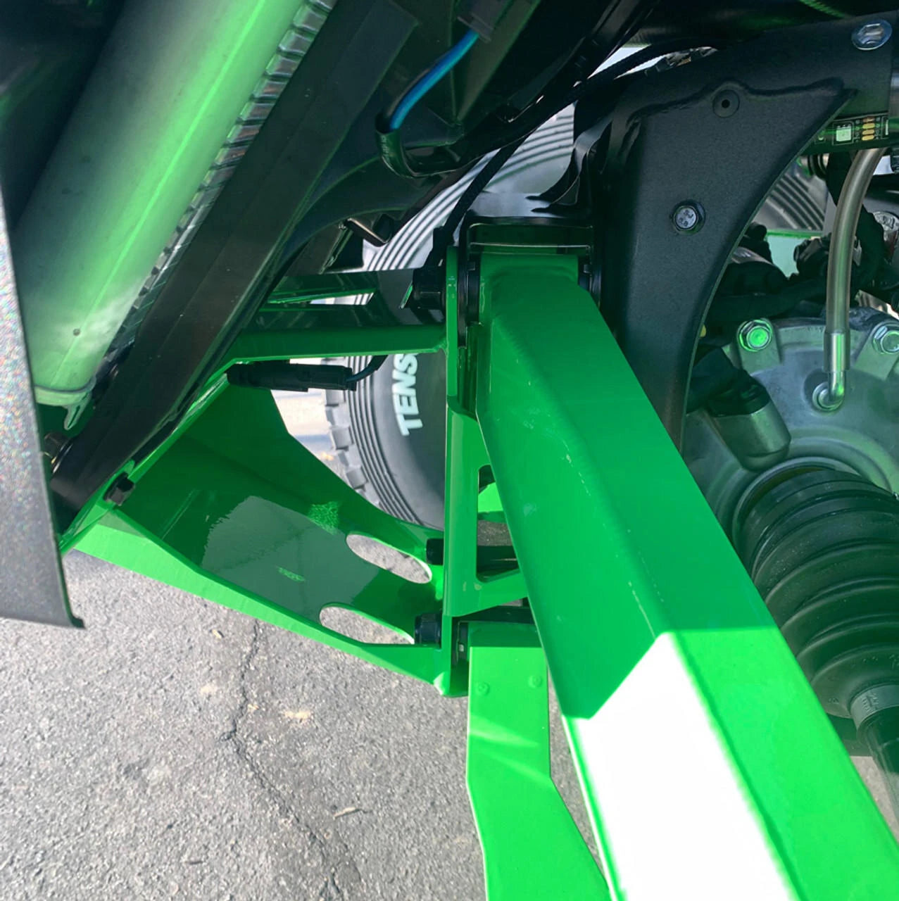 Close-up of a green agricultural machine with visible branding on a blurred background