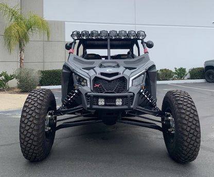 Off-road vehicle with large tires and additional lights on a concrete surface.