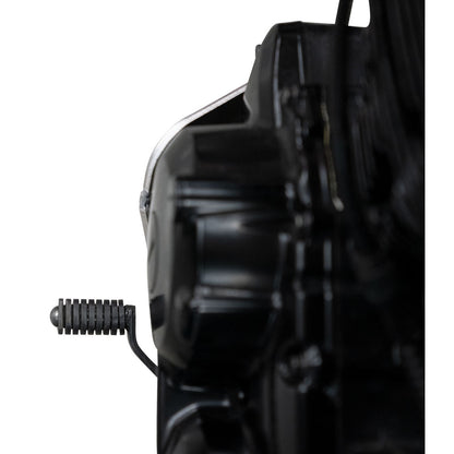 Close-up of a black motorcycle engine component and footpeg against a white background.