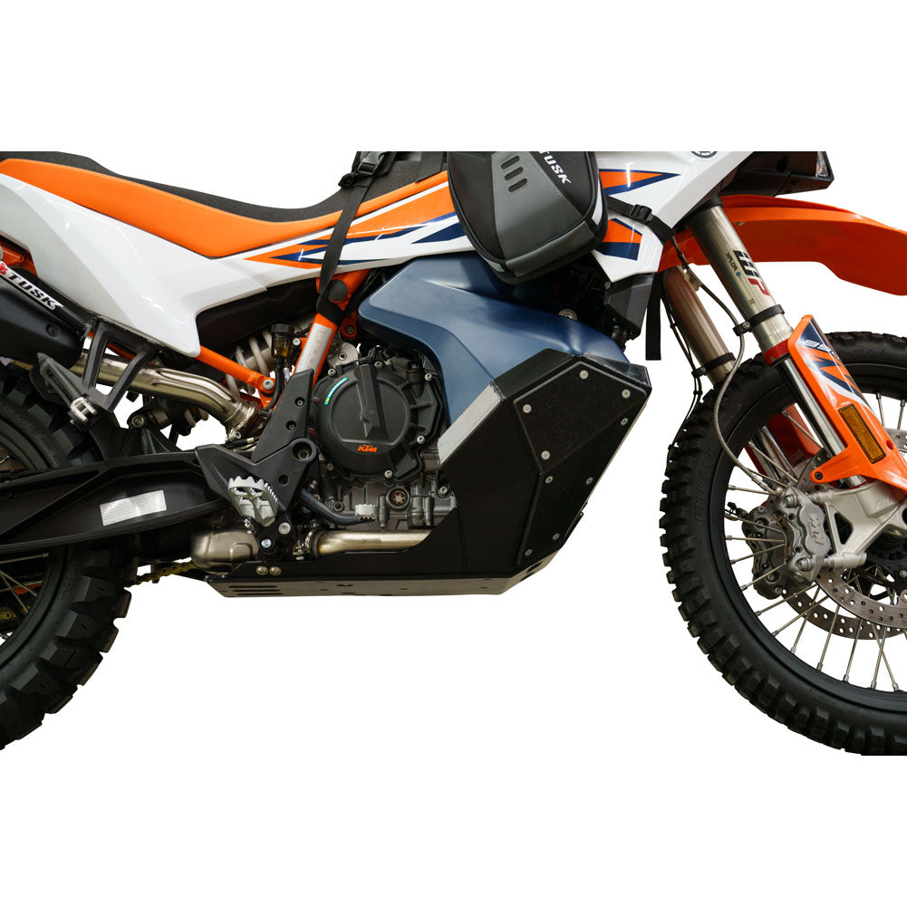 Side view of a motorcycle with protective black engine guards, a blue and orange body panel, and a white front fender on a white background.