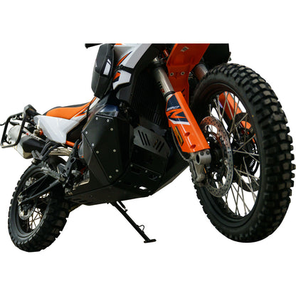 Black metal side armor plates with silver rivets and a matte finish, shown installed on an orange and black off-road motorcycle against a white background.