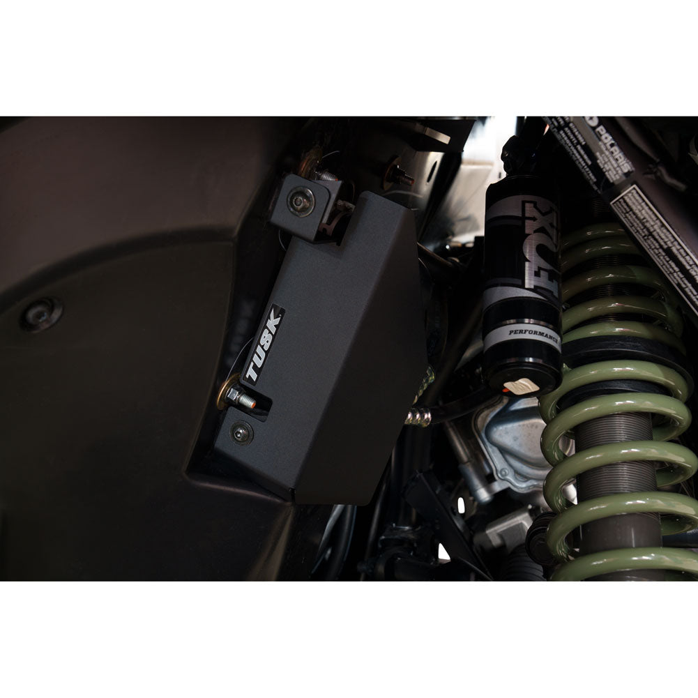 Close-up of a suspension system with a shock absorber and Tusk brand logo.