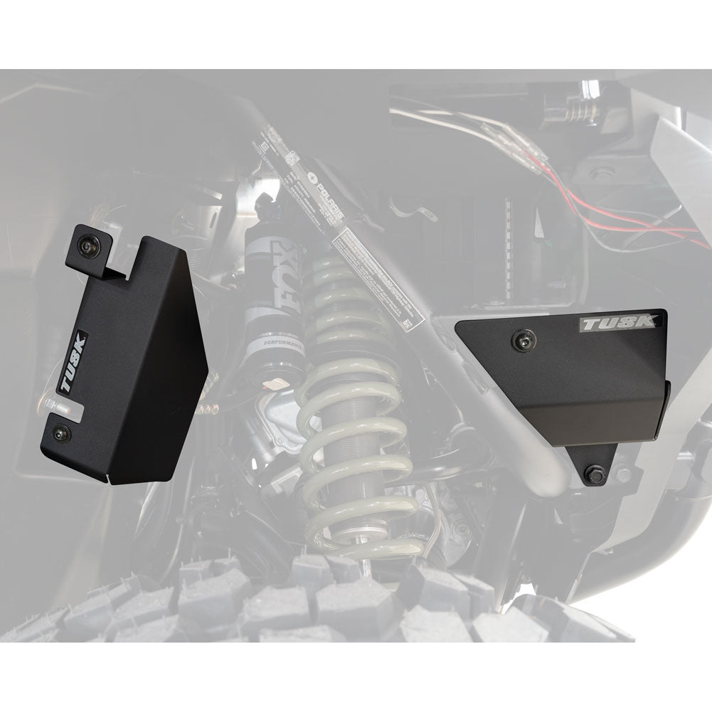 Two black metal brackets on a vehicle suspension system with 'Tusk' branding.