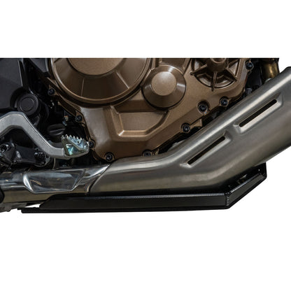 A close-up of a motorcycle engine and exhaust system with a black side cover or shield, shown against a plain white background.