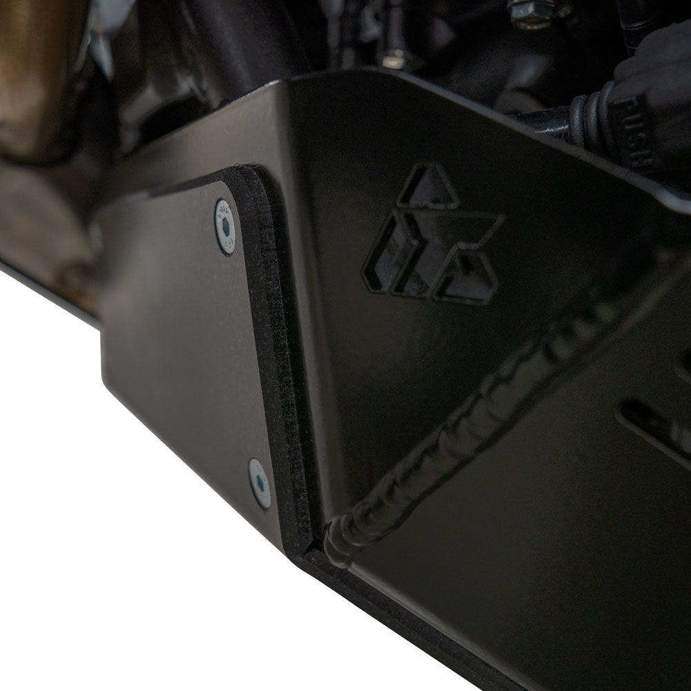 Close-up of a black metal engine or chassis component with a molded logo and visible screws, photographed against a white background.
