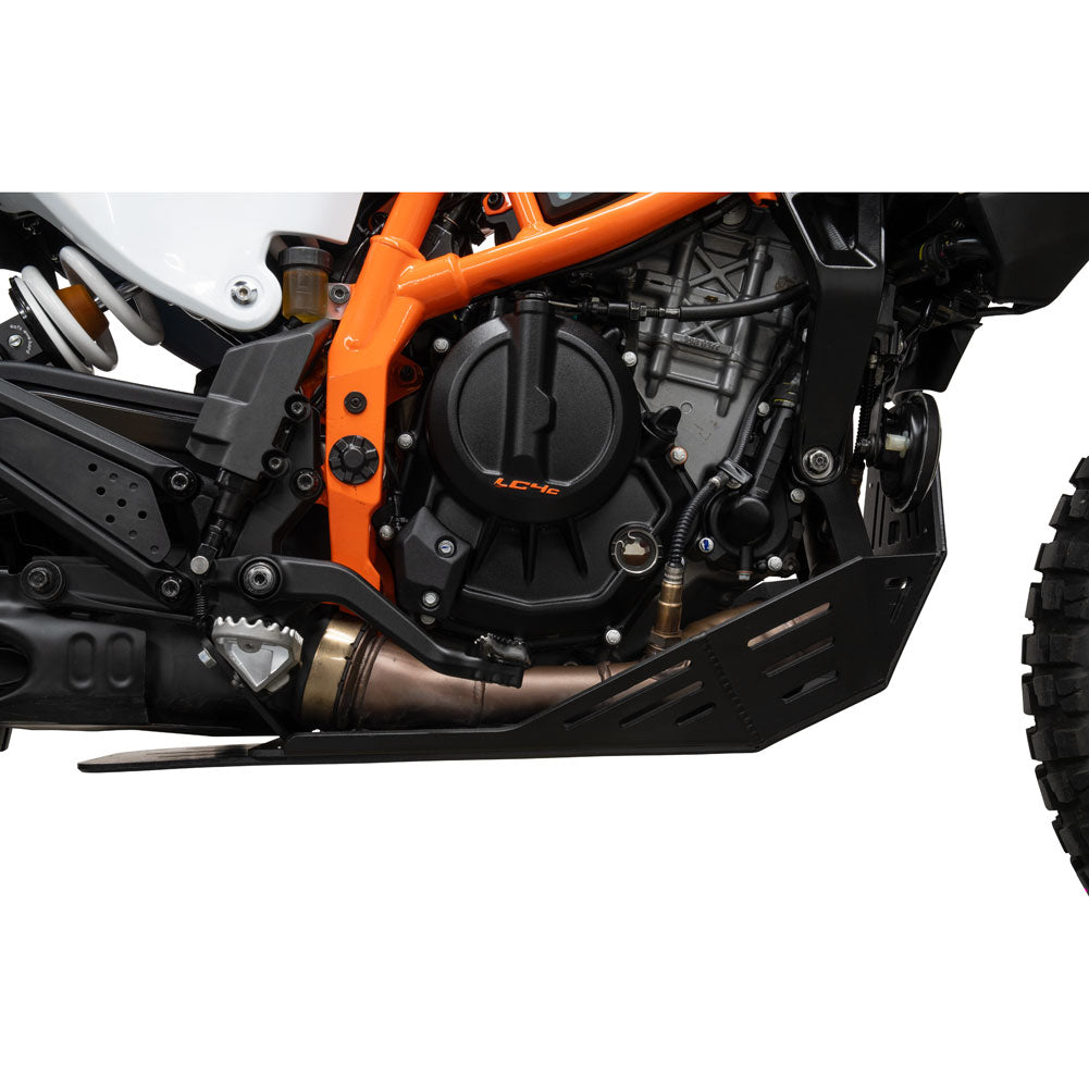 Close-up of a motorcycle engine and exhaust system with an orange frame, black engine casing, and a black protective skid plate on a white background.