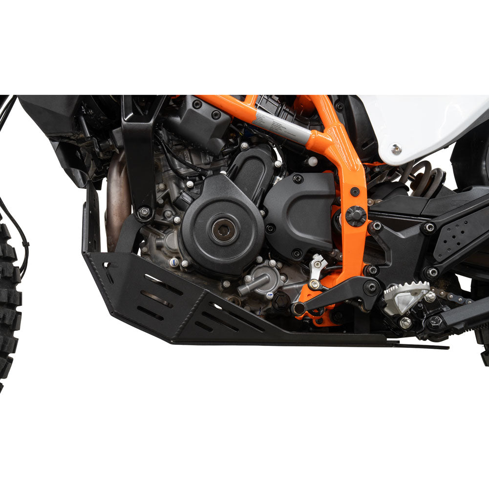 A close-up of a black metal engine guard and skid plate installed on an off-road motorcycle, showing the orange frame and engine components against a white background.