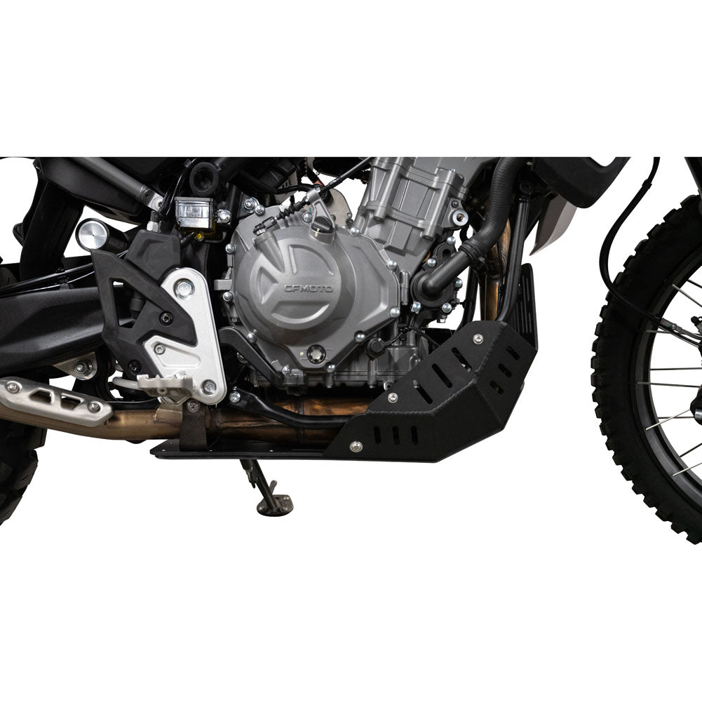 A close-up side view of a motorcycle engine and side panel, showing a black protective skid plate mounted over the exhaust and engine area on a white studio background.